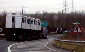 Tube train on the back of a lorry on the motorway: 1