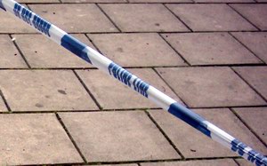 Police tape against paving stones