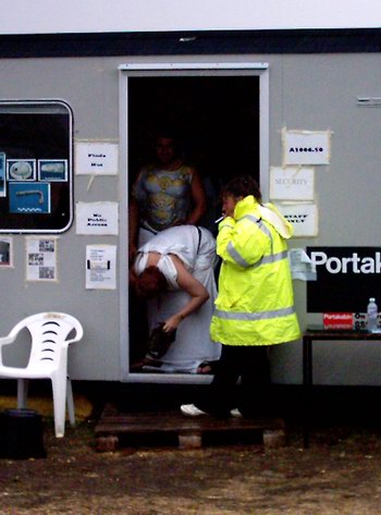 Costumed students shelter from the rain in a Portakabin